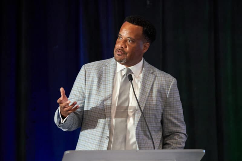 A close-up shot of Jay Williams speaking at a podium